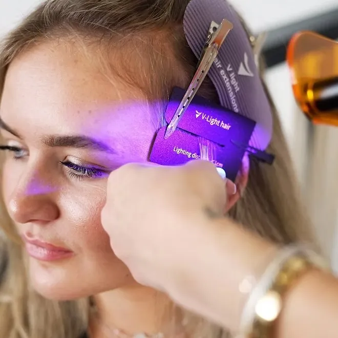 Gros plan sur la lumière froide V-Light appliquée à la racine, sans chaleur sur le cheveu